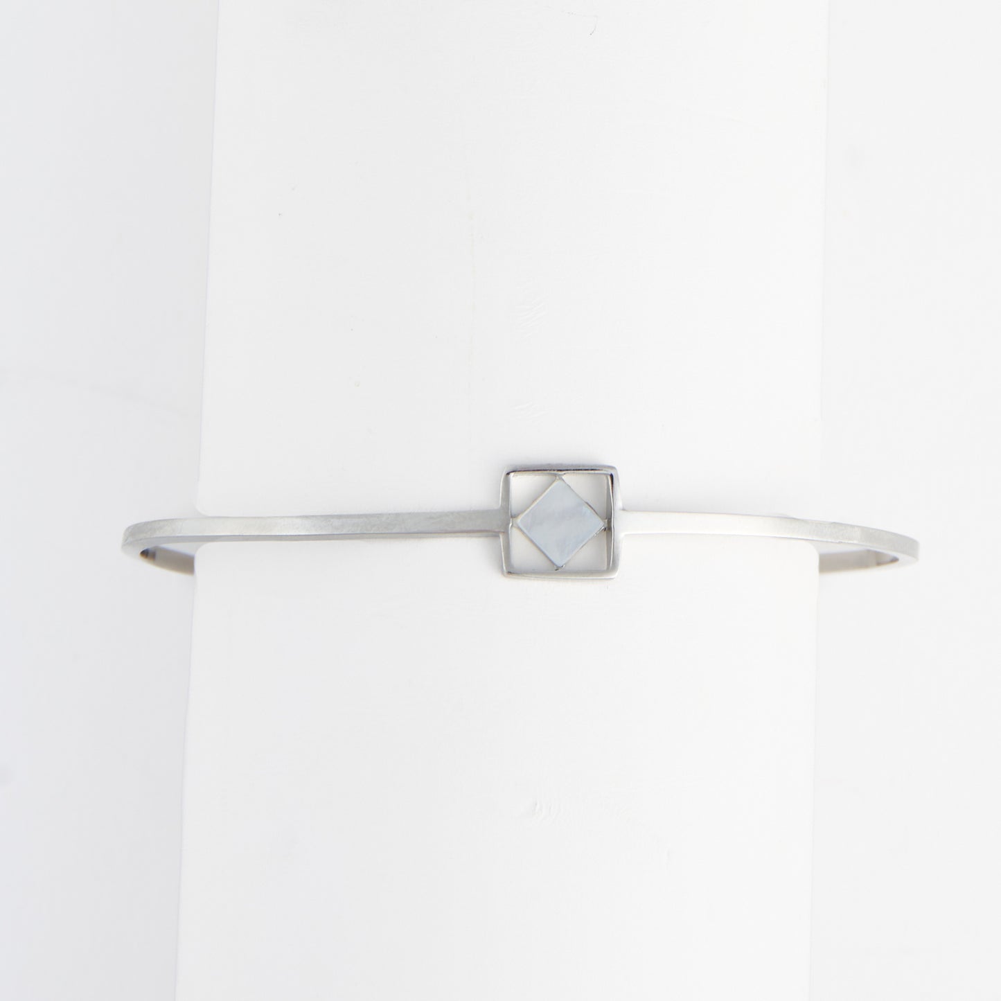 Silver bracelet with a geometric design on a white background