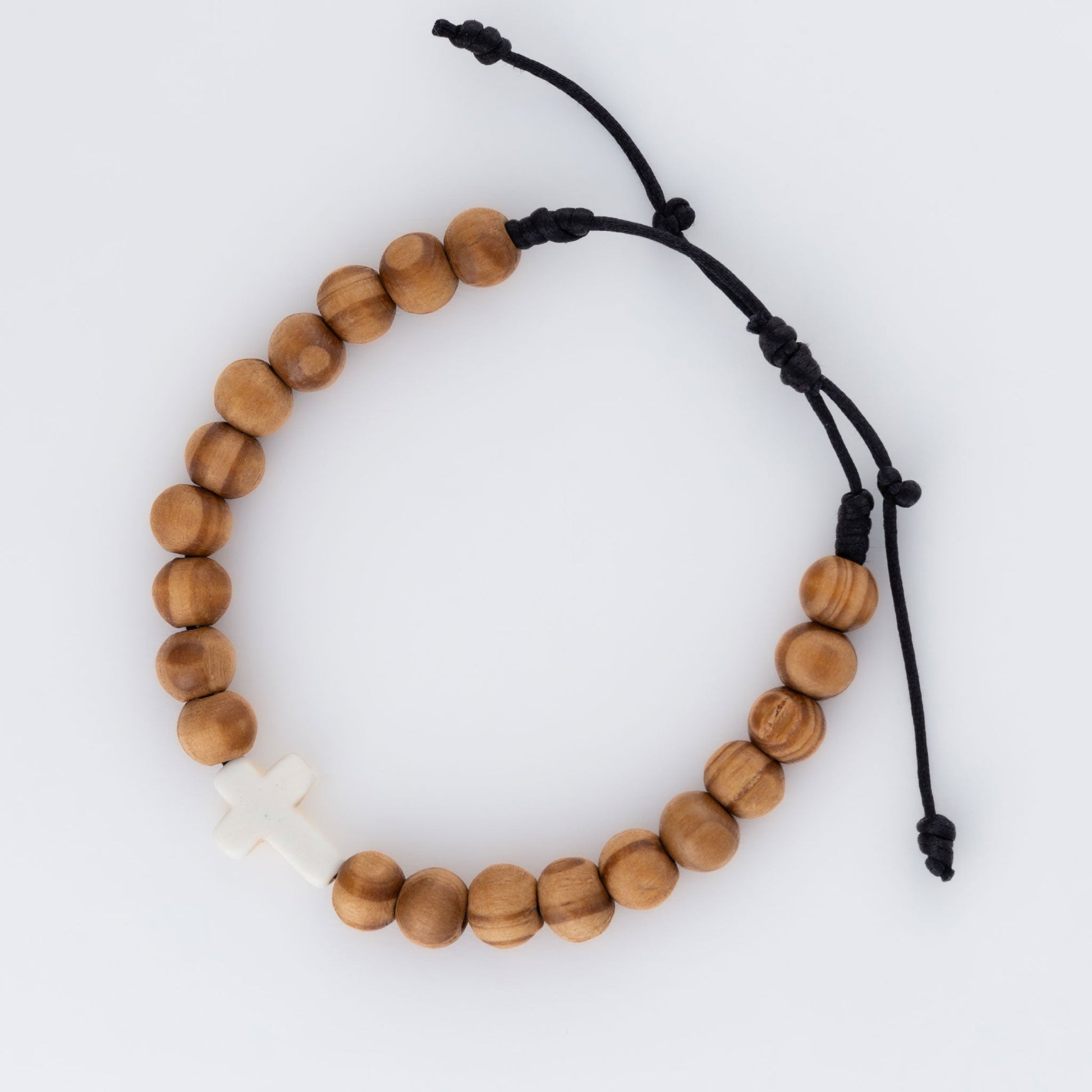 A beaded bracelet with round wood beads and a white cross charm