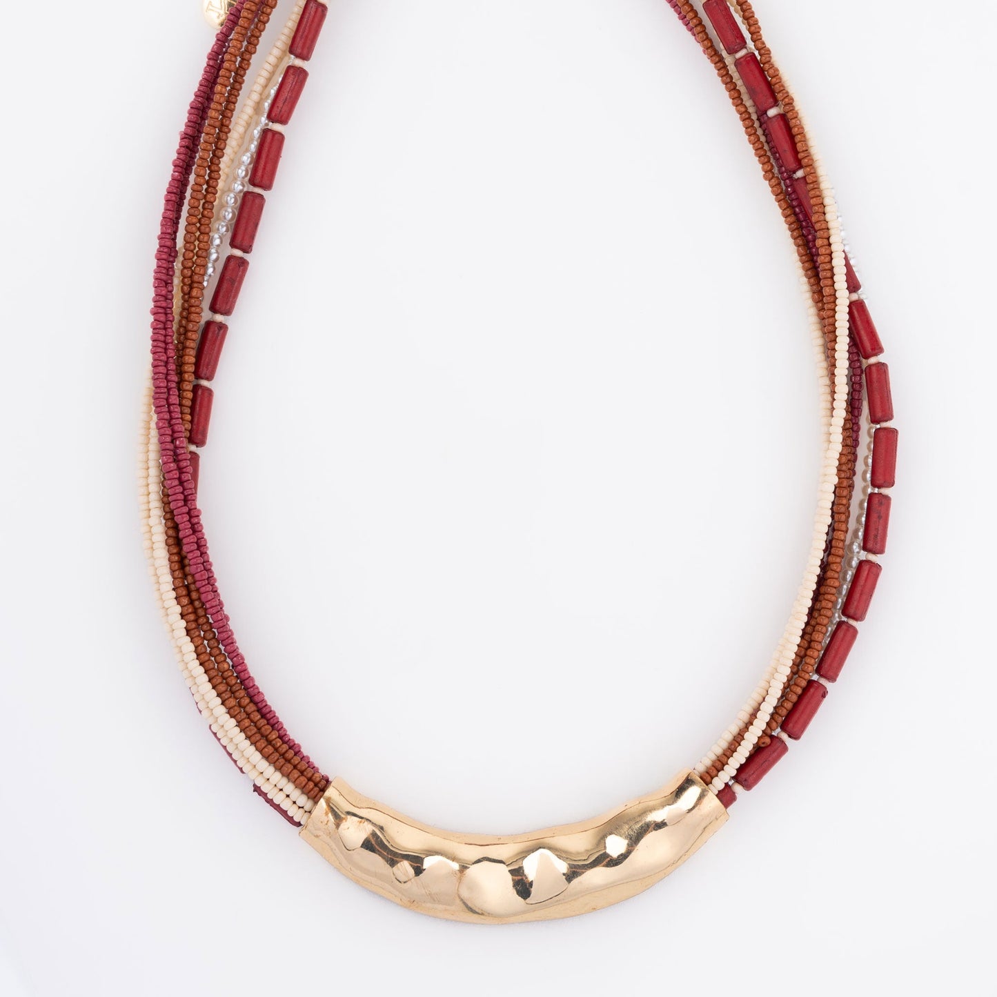 A seed bead necklace in red and gold colors with hammered metal detailing