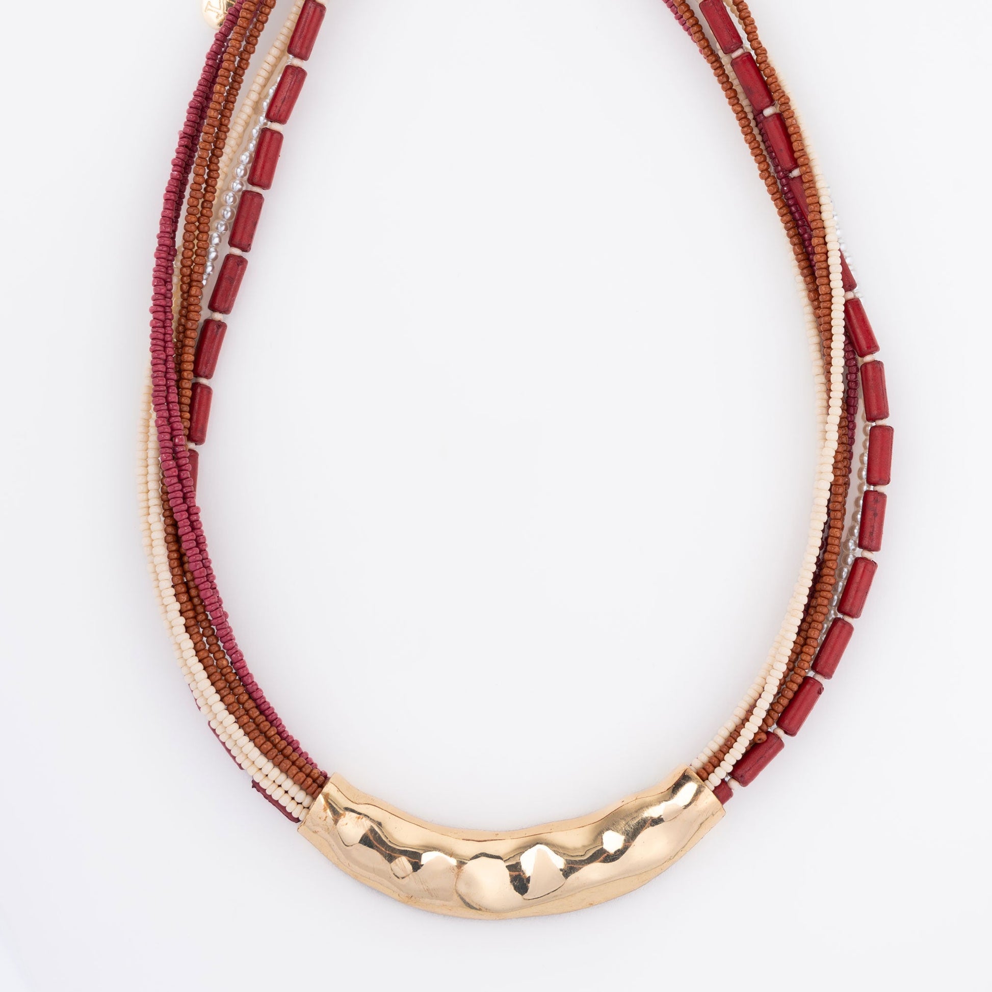 A seed bead necklace in red and gold colors with hammered metal detailing