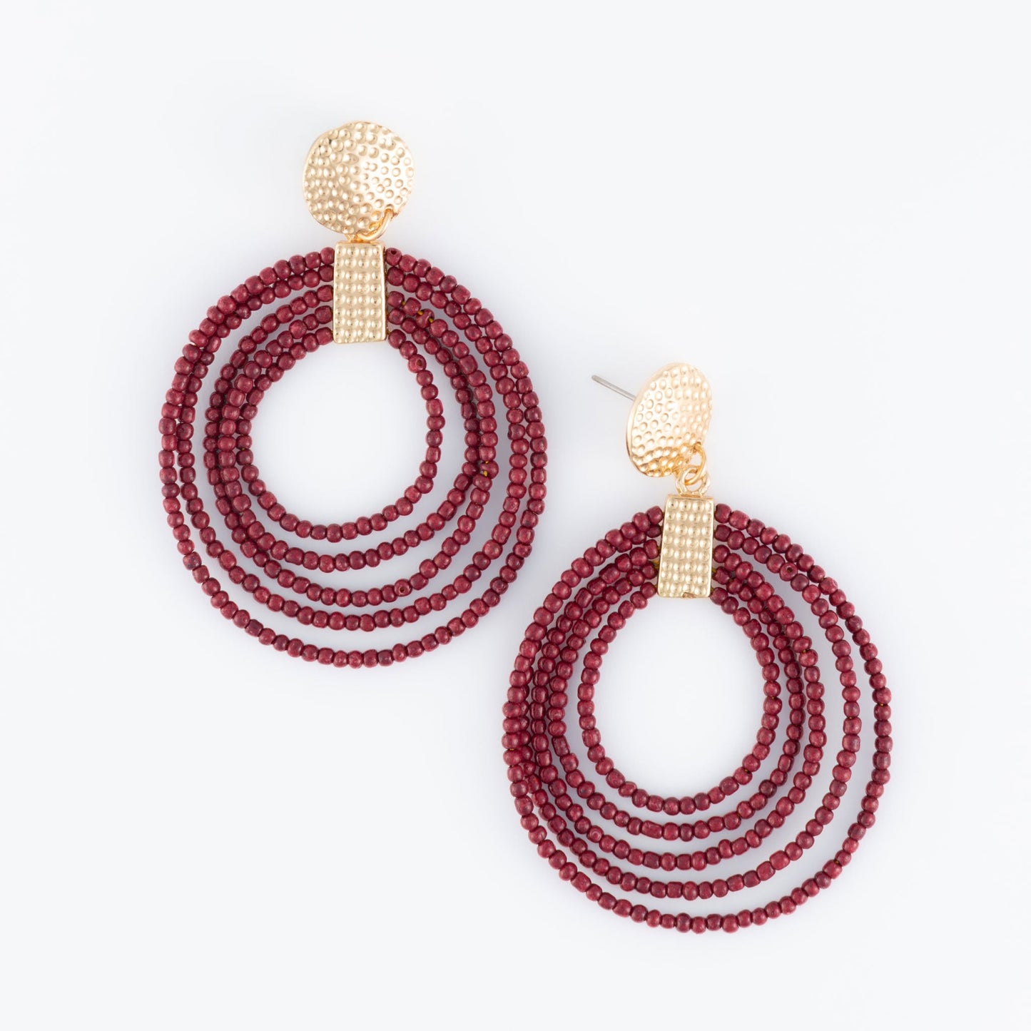 A pair of hoop earrings made of red seed beads with gold detailing at the top.