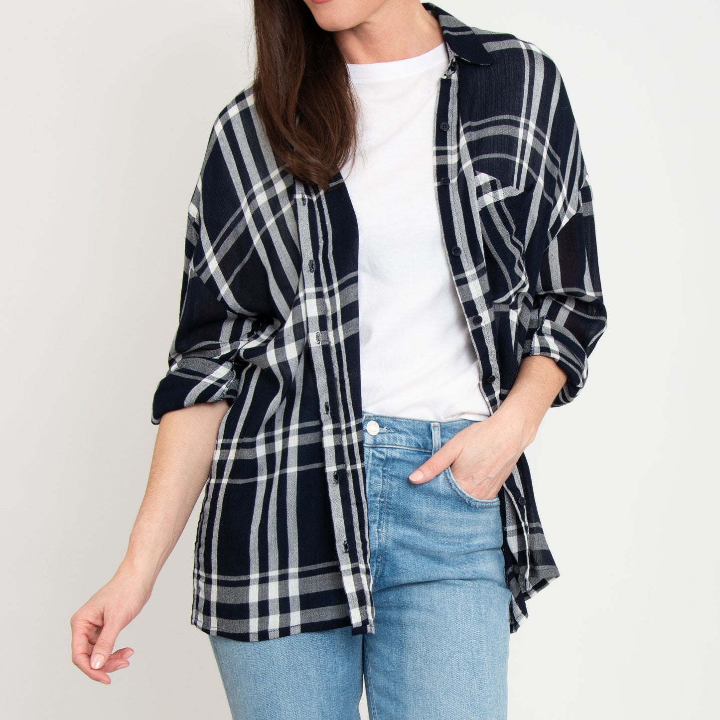 A woman wearing a navy plaid lightweight button up top