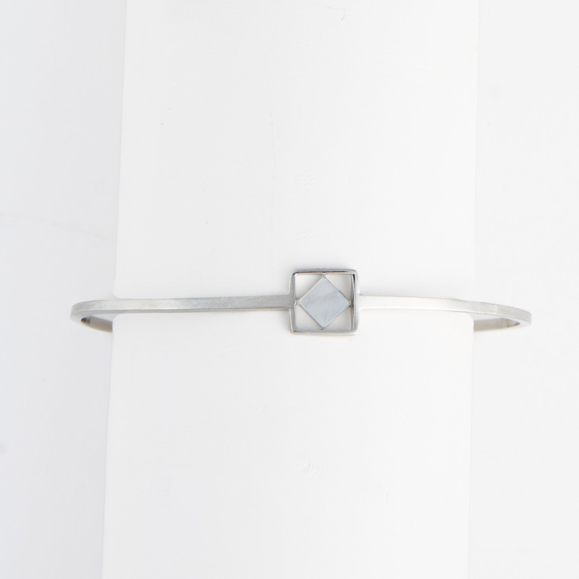 Silver bracelet with a geometric design on a white background