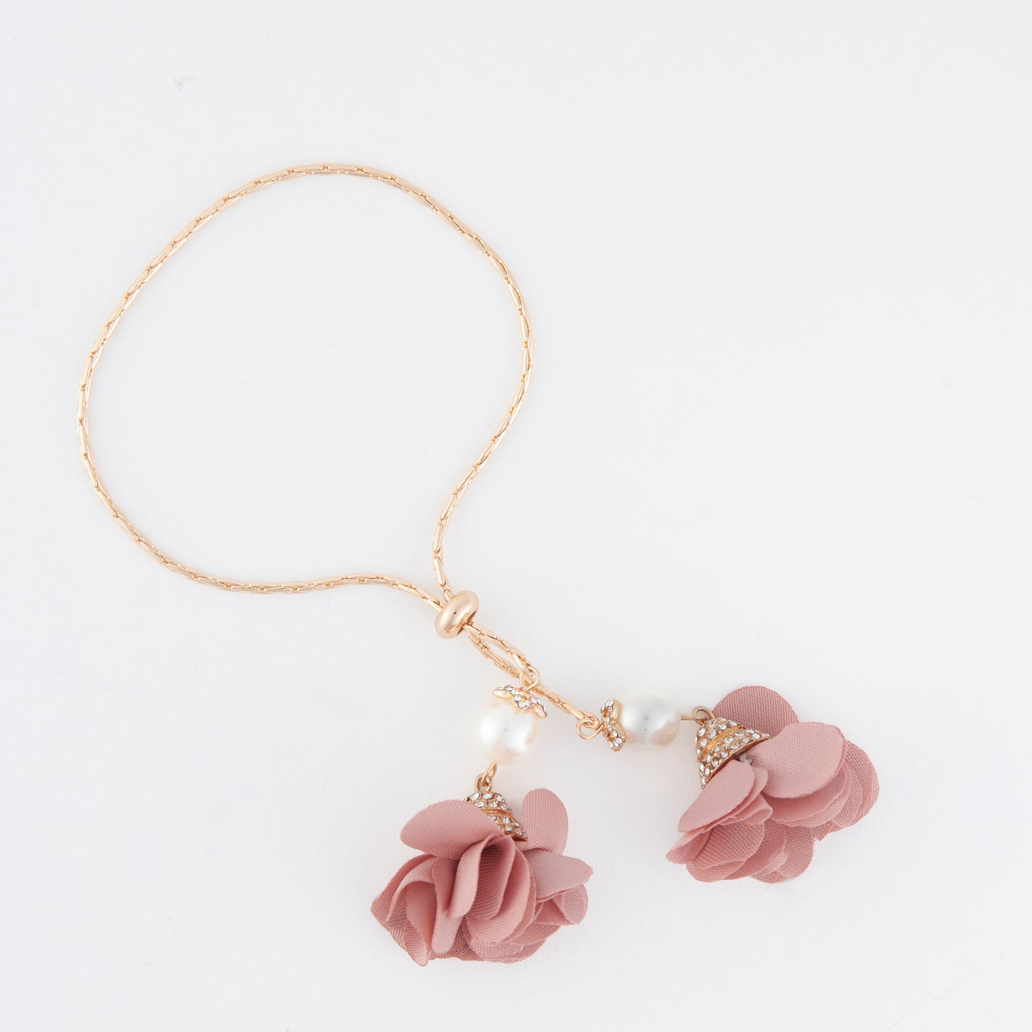 Pink floral bracelet with gold accents on a white background