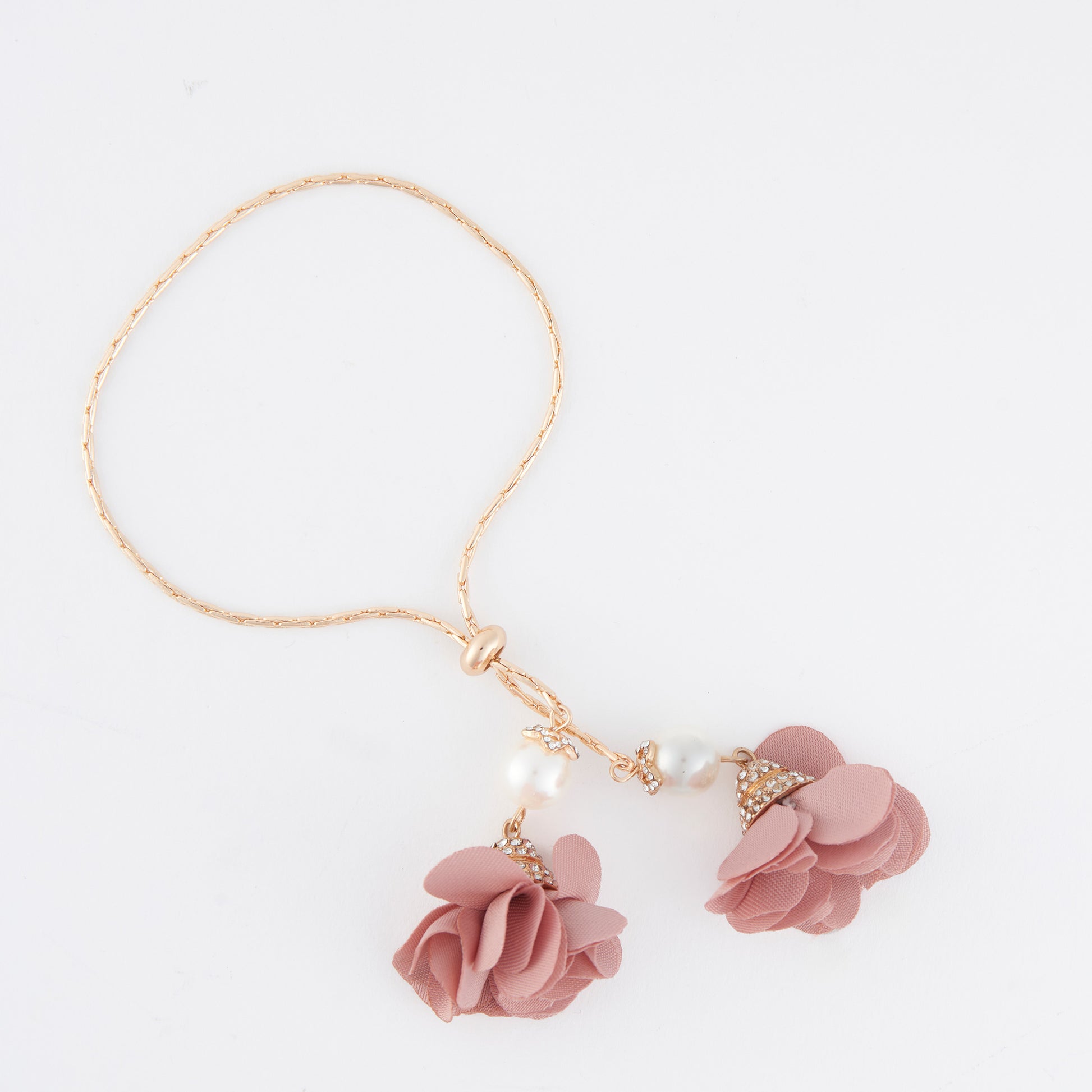 Pink floral bracelet with gold accents on a white background