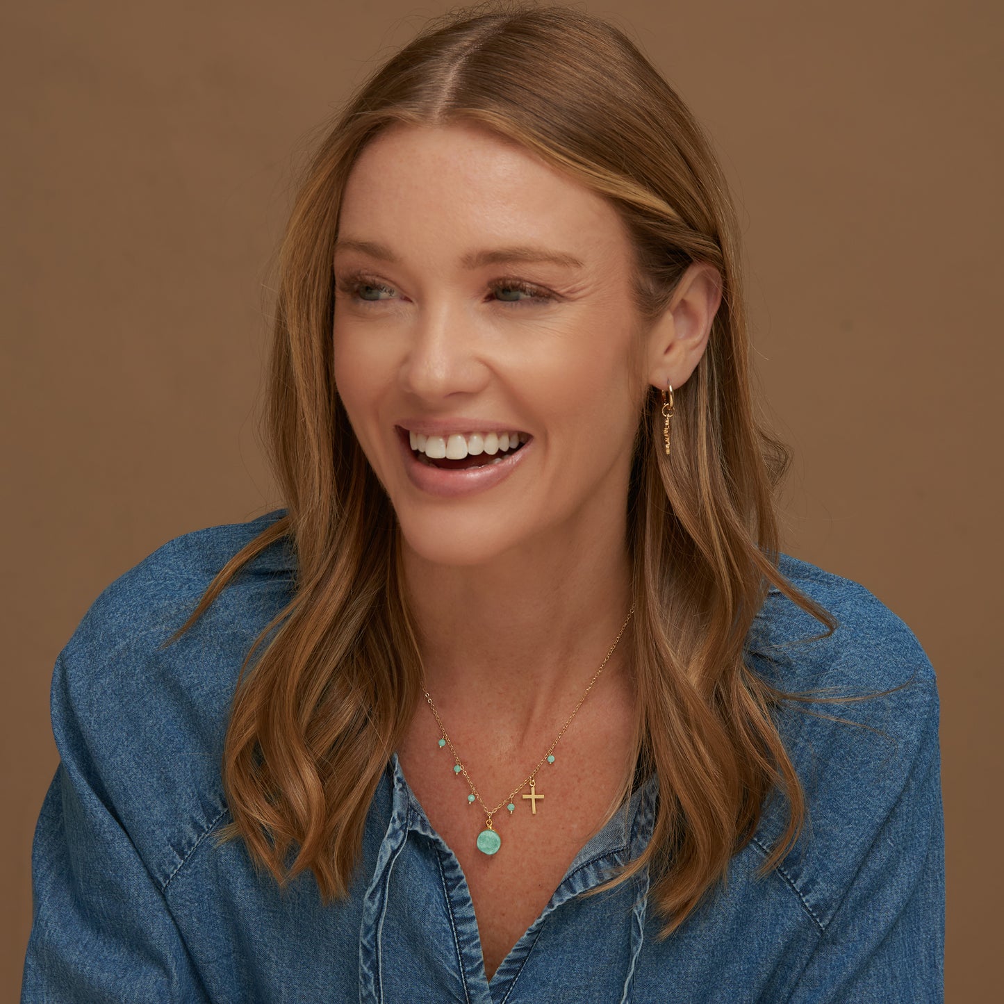Woman wearing a blue denim shirt with a brown background